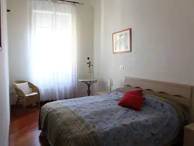 a bedroom with a bed with a red pillow on it at Apartment Appartement mit Dachterrasse by Interhome in Rome