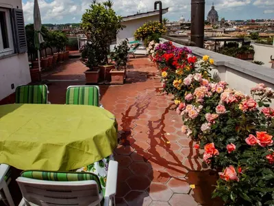 a patio with a table and flowers on a balcony at Apartment Appartement mit Dachterrasse by Interhome in Rome