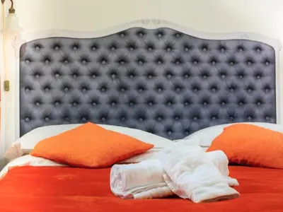 a bed with white towels and orange pillows on it at Apartment Charmantes- komfortables Studio im Herzen von Rom by Interhome in Rome