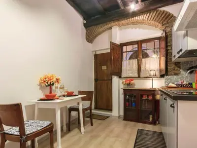 a kitchen with a table and chairs in a room at Apartment Charmantes- komfortables Studio im Herzen von Rom by Interhome in Rome