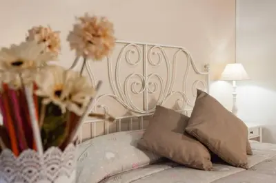 a white bed with a vase of flowers on it at House&Colosseum in Rome