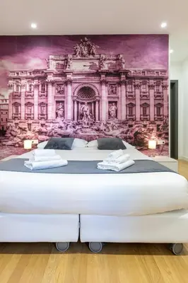 a bedroom with a large white bed with a painting on the wall at Trevi Elite Rome in Rome