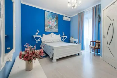a blue bedroom with a bed and a vase of flowers at Ai 7 Scalini in Rome