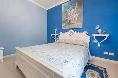 a blue bedroom with a bed with a white bedspread at Ai 7 Scalini in Rome
