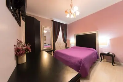 a bedroom with a purple bed and a black table at Ai 7 Scalini in Rome