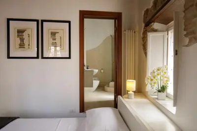 a bedroom with a bed and a bathroom at The Right Place 4U Navona Luxury Rooms in Rome