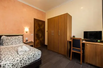 a bedroom with a bed and a desk with a television at Guest's Heaven in Rome