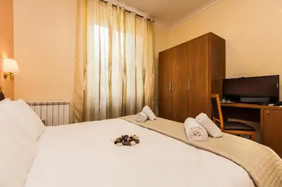 a bedroom with a large white bed with towels on it at Guest's Heaven in Rome