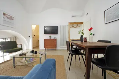 a living room with a table and chairs and a tv at Luxury Spagna Apartments in Rome