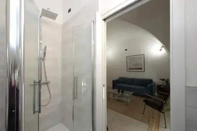 a bathroom with a shower and a blue couch at Luxury Spagna Apartments in Rome