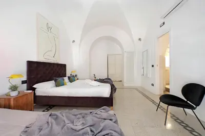 a bedroom with two beds and a chair at Luxury Spagna Apartments in Rome