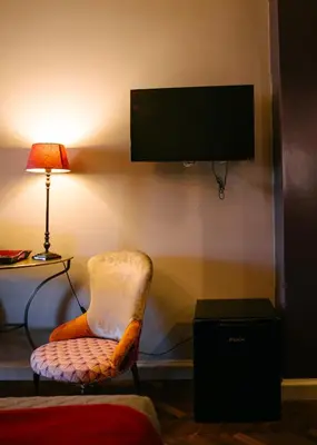 a room with a chair and a television on a wall at Terrazza Munira Trastevere in Rome