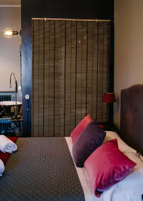 a bed with pink and purple pillows on it at Terrazza Munira Trastevere in Rome
