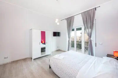 a white bedroom with a bed and a large window at Rome To You- The Place to be&B in Rome