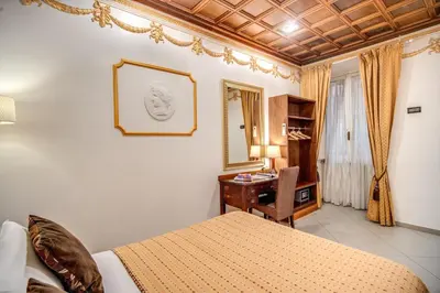 a bedroom with a bed and a desk and a mirror at Artemis in Rome