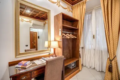 a room with a desk with a mirror and a lamp at Artemis in Rome