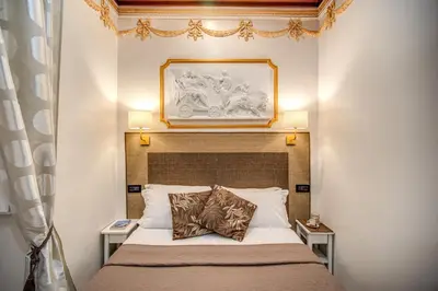 a bedroom with a bed with a picture above it at Artemis in Rome