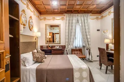 a bedroom with a bed and a desk and a mirror at Artemis in Rome
