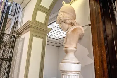 a statue of a woman on a column in a museum at Artemis in Rome