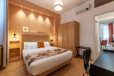 a bedroom with a large bed and a desk and a table at Appartamento moderno e silenzioso a Trastevere in Rome
