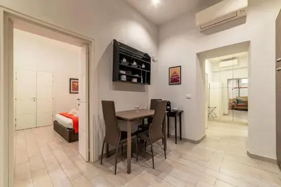 a dining room with a table and chairs and a bedroom at Loft tra Castel Sant'Angelo e centro storico in Rome