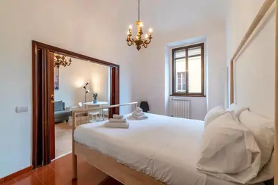 a bedroom with a large white bed and a mirror at Tipico appartamento nel cuore di Trastevere in Rome