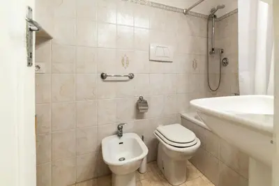 a white bathroom with a toilet and a sink at Tipico appartamento nel cuore di Trastevere in Rome