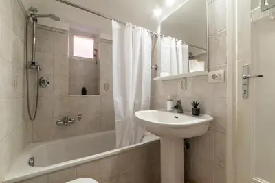 a white bathroom with a sink and a tub and a toilet at Tipico appartamento nel cuore di Trastevere in Rome