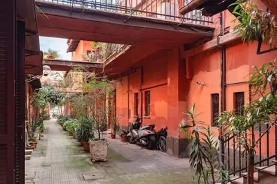 an alley with a motorcycle parked next to an orange building at Tipico appartamento nel cuore di Trastevere in Rome