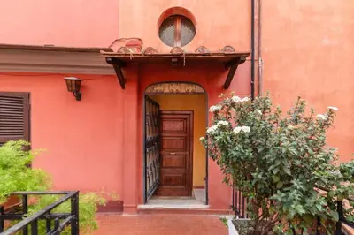 an orange building with a wooden door and a gate at Tipico appartamento nel cuore di Trastevere in Rome