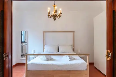 a bedroom with a bed and a chandelier at Tipico appartamento nel cuore di Trastevere in Rome