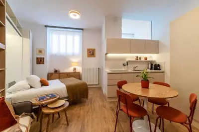 a bedroom with a bed and a table and a kitchen at Loft moderno e silenzioso a Trastevere in Rome