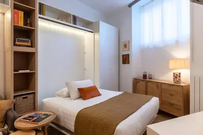 a small bedroom with a bed and a desk at Loft moderno e silenzioso a Trastevere in Rome