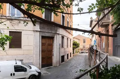 a white car parked on a street with buildings at Loft moderno e silenzioso a Trastevere in Rome