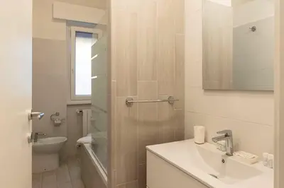 a white bathroom with a sink and a toilet at Vivace appartamento con splendido giardino in Rome