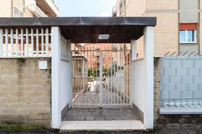 a gate leading into a building with a bench at Vivace appartamento con splendido giardino in Rome