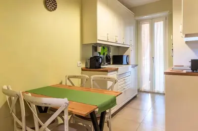 a kitchen with a table and chairs in a room at Nuovo e ampio appartamento vicino metropolitana in Rome