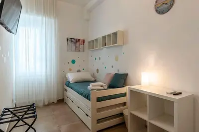 a small bedroom with a bed and a desk at Nuovo e ampio appartamento vicino metropolitana in Rome