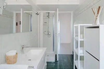 a white bathroom with a sink and a shower at Appartamento panoramico vicino San Pietro e Vaticano in Rome