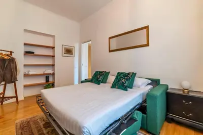 a bedroom with a bed and a dresser at Appartamento nel cuore del pittoresco Pigneto in Rome