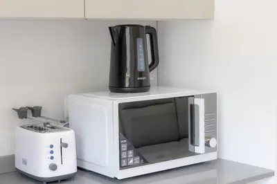 a microwave with a coffee pot on top of it at Nuovo appartamento ben collegato con il centro in Rome