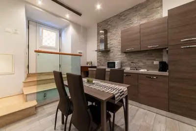 a kitchen with a table and chairs in a room at 3 comodi posti letto vicino Castel Sant'Angelo in Rome