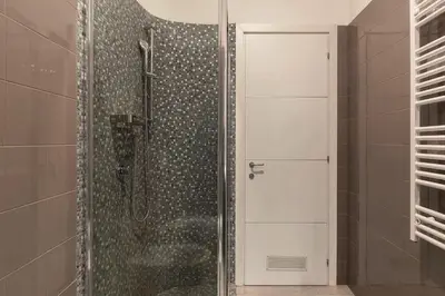 a shower with a glass door in a bathroom at 3 comodi posti letto vicino Castel Sant'Angelo in Rome