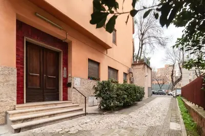 a building with a wooden door and stairs on a street at Appartamento moderno a 5 minuti dal Vaticano in Rome
