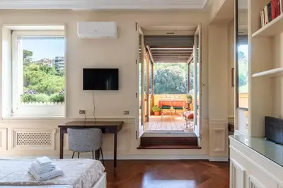 a room with a desk and a window and a table at Delizioso loft con terrazzo panoramico a Flaminio in Rome