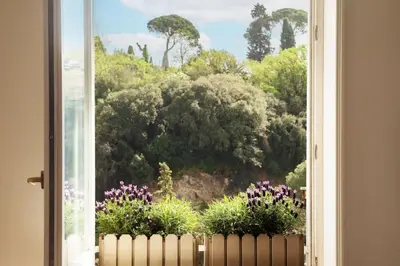 a window with a view of trees and flowers at Delizioso loft con terrazzo panoramico a Flaminio in Rome