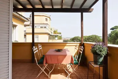 a patio with a table and chairs on a balcony at Delizioso loft con terrazzo panoramico a Flaminio in Rome