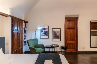 a bedroom with a bed and a chair and a table at Loft a due passi dal Pantheon in Rome