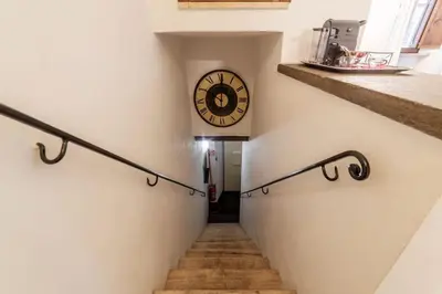 a stairway with a clock on the side of a building at Loft a due passi dal Pantheon in Rome