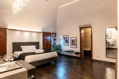 a bedroom with a bed and a chair in a room at Loft a due passi dal Pantheon in Rome
